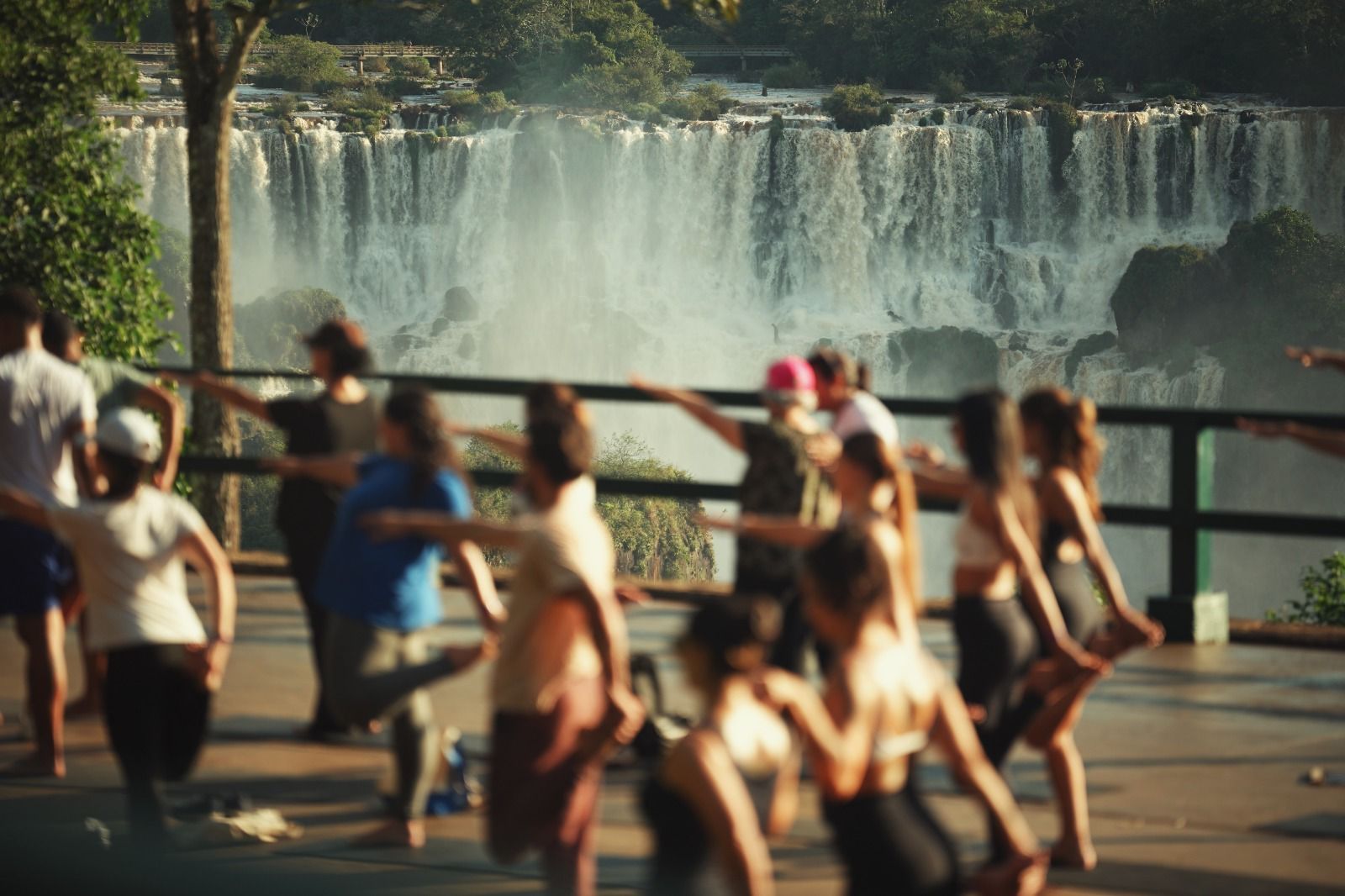 Leitores VIP praticando yoga e pedalando em frente às Cataratas do Iguaçu em celebração ao aniversário de Foz do Iguaçu em 2026.